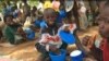 Des élèves savourant leur déjeuner à l'école primaire publique de Louanga, Togo, 23 mai 2017. (VOA/Kayi Lawson).