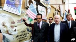 Le sénateur John McCain (à droite) et Abdul Hafiz Ghoqa, porte-parole du Conseil national de transition