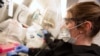 Kylene Karnuth works with coronavirus samples as researchers begin a trial to see whether malaria treatment hydroxychloroquine can prevent or reduce the severity of COVID-19, at the University of Minnesota in Minneapolis, March 19, 2020.