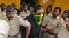 An accused man (face covered), surrounded by Indian policemen, is taken to a court in Mumbai, India, Sept. 11, 2015. 