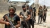 FILE - Fighters from the Popular Mobilization units deploy in the city of Baiji, north of Tikrit, as they fight alongside Iraqi forces against the Islamic State, June 9, 2015. 