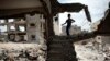 A Palestinian boy plays amid the rubble of his family's former house, which was destroyed in the 2014 war between Israel and Hamas militants, in the Eastern Gaza City Shujaiya neighborhood, May 11, 2015.