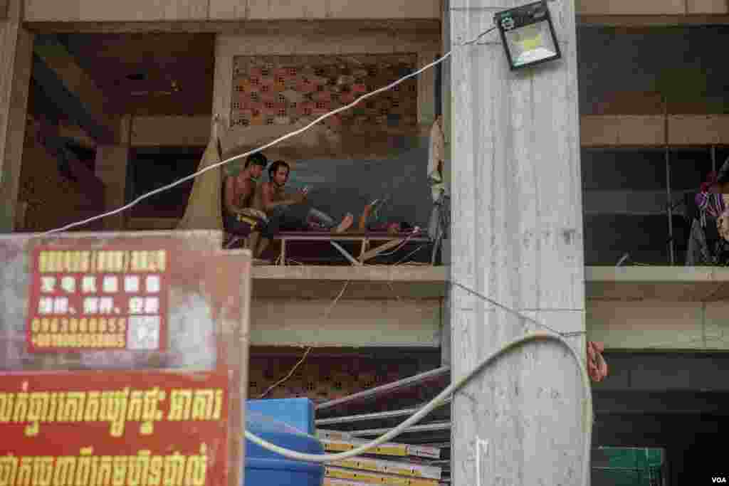កម្មករ​សំណង់​ប្រមាណ​​៣០នាក់ មក​ពី​ខេត្ត​ផ្សេង​ៗគ្នា​ កំពុង​ធ្វើ​ការ​ និងស្នាក់នៅ​ក្នុងអគារ​សំណង់ខុនដូ ដែល​ពុំទាន់សង់​រួចរាល់មួយ​កន្លែងនៅក្រុងព្រះសីហនុ, នៅថ្ងៃទី ២៥ ខែមិថុនា​ ឆ្នាំ២០១៩។​ (ខាន់ សុគុំមនោ​/VOA)