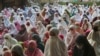 Muslims wear face mask as a precaution against the coronavirus during Eid al-Fitr prayer marking the end of the holy fasting month of Ramadan on a street in in Bekasi, West Java, Indonesia, Thursday, May 13, 2021. Muslims celebrated Eid al-Fitr in a…