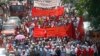 Lebanese leftist activists wave flags as they march during a demonstration to mark Labor Day, or May Day, along a street in Beirut, May 1, 2013.