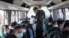 This handout photo taken and released on Nov. 18, 2023 by the Royal Thai Army shows Thai military personnel with some of the 41 Thai nationals on a bus to Mae Sai after they returned to Thailand after being trapped in Myanmar.