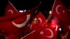 FILE - Government supporters wave Turkish flags and shout slogans during a protest in Taksim Square, Istanbul, July 19, 2016.
