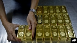 Seorang pegawai menyiapkan satu kilogram emas batangan murni di perusahaan Emirates Gold di Dubai, Uni Emirat Arab, 9 Oktober 2012. (Foto: Kamran Jebreili/AP Photo/arsip)